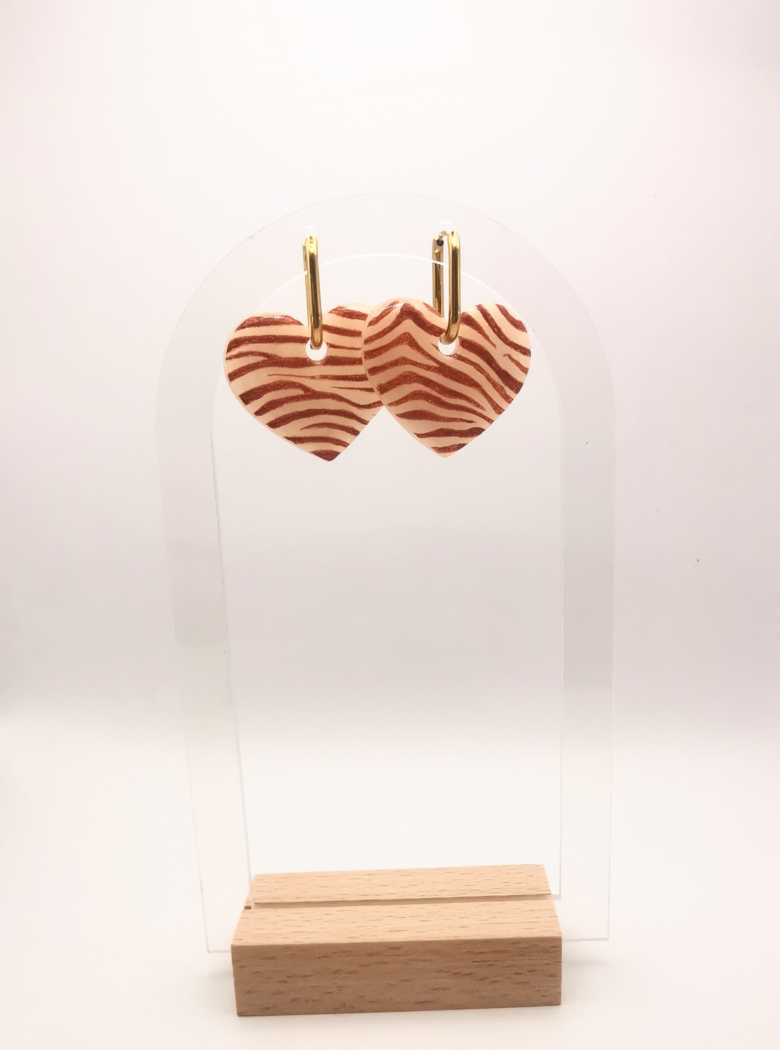 Boucle d'oreille coeur zébré orange et translucide créole sur présentoir