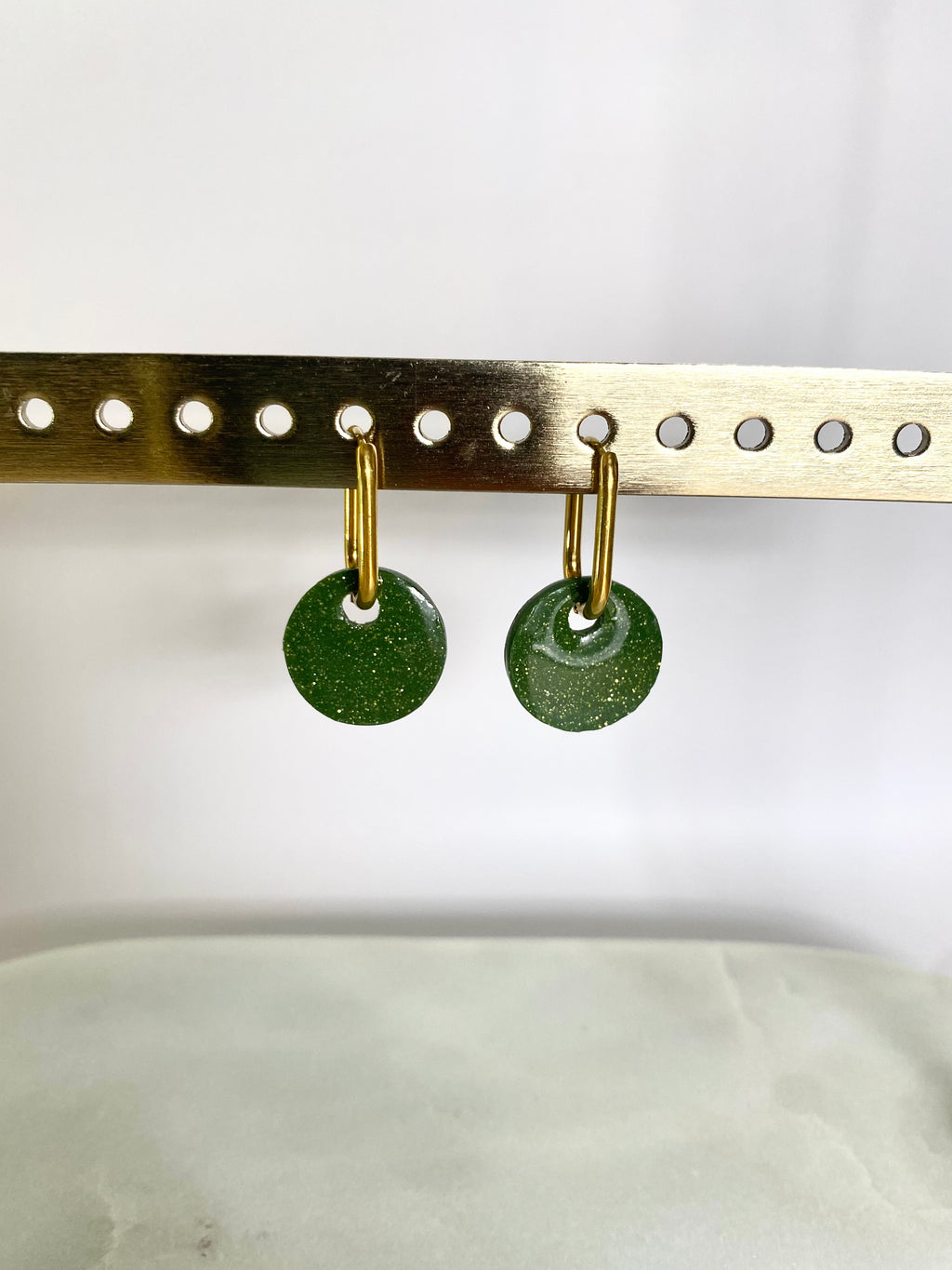 Boucle d'oreille pastille vert olive pailleté portée sur mannequin élégant