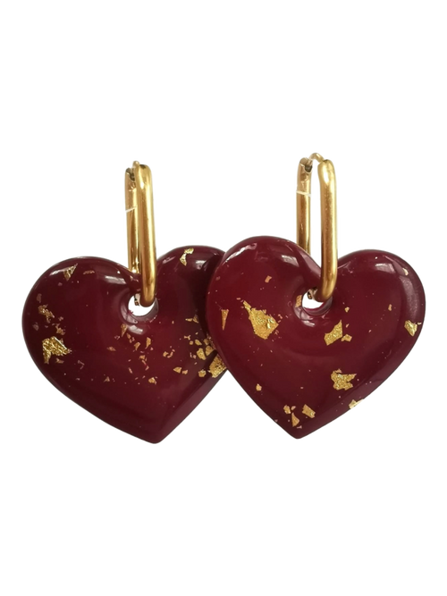 Boucles d'oreilles pendantes forme cœur rouge bordeaux avec éclats de feuilles d'or et créoles dorées.